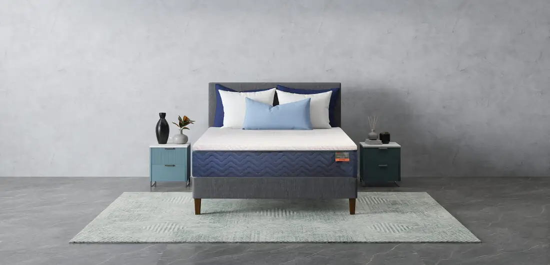 A finished Beloit mattress with navy quilted sides made up on a bed in a calm bedroom