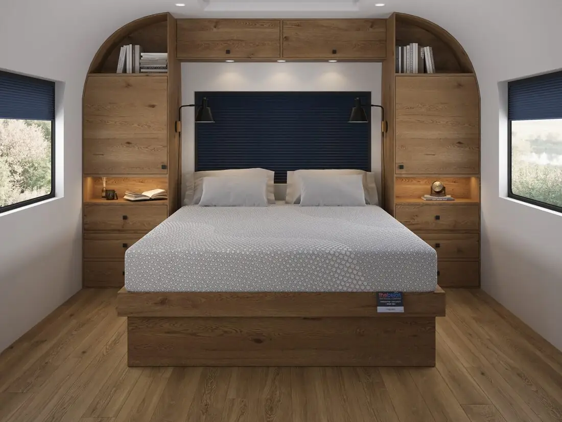 A made-to-fit Beloit mattress in a camper bedroom with a wood headboard